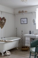 Salle de bains à l'ancienne avec mur à rainure et languette et baignoire sur roulettes