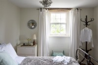 Chambre luxueuse de couleur pâle avec lit en fer
