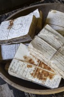 Des paquets de vieilles pages de livres attachées avec de la ficelle et tachées