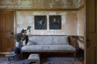 Peintures de portraits vintage dans un salon rustique avec des murs en détresse