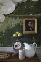Portrait encadré doré sur mur vert peint en détresse