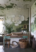Table en bois dans une cuisine rustique avec murs peints en détresse