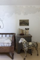 Sculpture de cheval antique à côté du lit de repos dans une chambre de style vintage