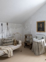 Petit lavabo dans une chambre vintage avec lit de repos à cadre rouillé