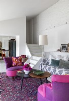Chaises roses et violettes dans un salon éclectique