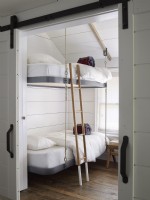 Chambre d'enfants avec lits superposés suspendus et portes de grange 