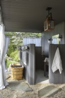 Salle de bain extérieure avec douche, lavabo et baignoire 