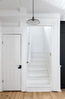 Escalier peint en blanc dans un couloir de campagne en bois 