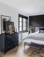Chambre moderne avec mur peint en noir derrière le lit 