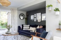 Salon moderne avec canapé en velours bleu et mur d'accent gris foncé 
