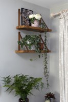 Plantes d'intérieur sur des étagères rustiques dans un salon gris et blanc 
