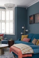 Coin salon audacieux avec murs bleu foncé et canapé en velours 