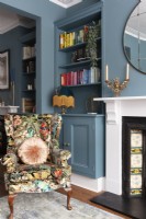 Salon peint en bleu vif avec fauteuil à imprimé botanique 