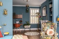 Salon coloré avec murs et volets peints en bleu 
