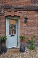 Couronne de Noël sur porte d'entrée traditionnelle gris vert 