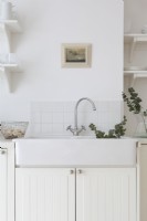 Évier en céramique blanche dans une cuisine blanche de style scan 
