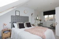 Chambre mezzanine avec tête de lit grise et jeté tricoté rose 