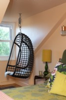Chaise suspendue dans une chambre loft colorée 