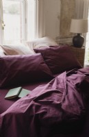 Linge de lit français prune sur lit défait 