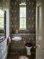 Salle de bains avec papier peint à fleurs et sol en pierre 
