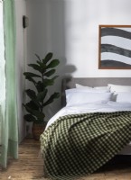 Couverture vichy verte avec linge de lit en coton blanc sur lit double 
