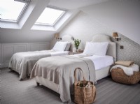 Chambre à lits jumeaux convertie en loft neutre avec lucarnes 