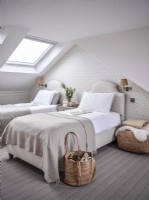 Chambre aménagée en loft neutre avec lits jumeaux et lucarne 