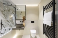 Salle de bains moderne avec murs en marbre et accessoires noirs 