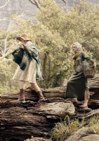 Deux femmes marchant sur un grand arbre tombé dans les bois 